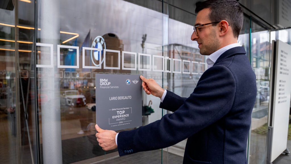 Vediamo un uomo che applica la targa del Top Experience Award alla finestra